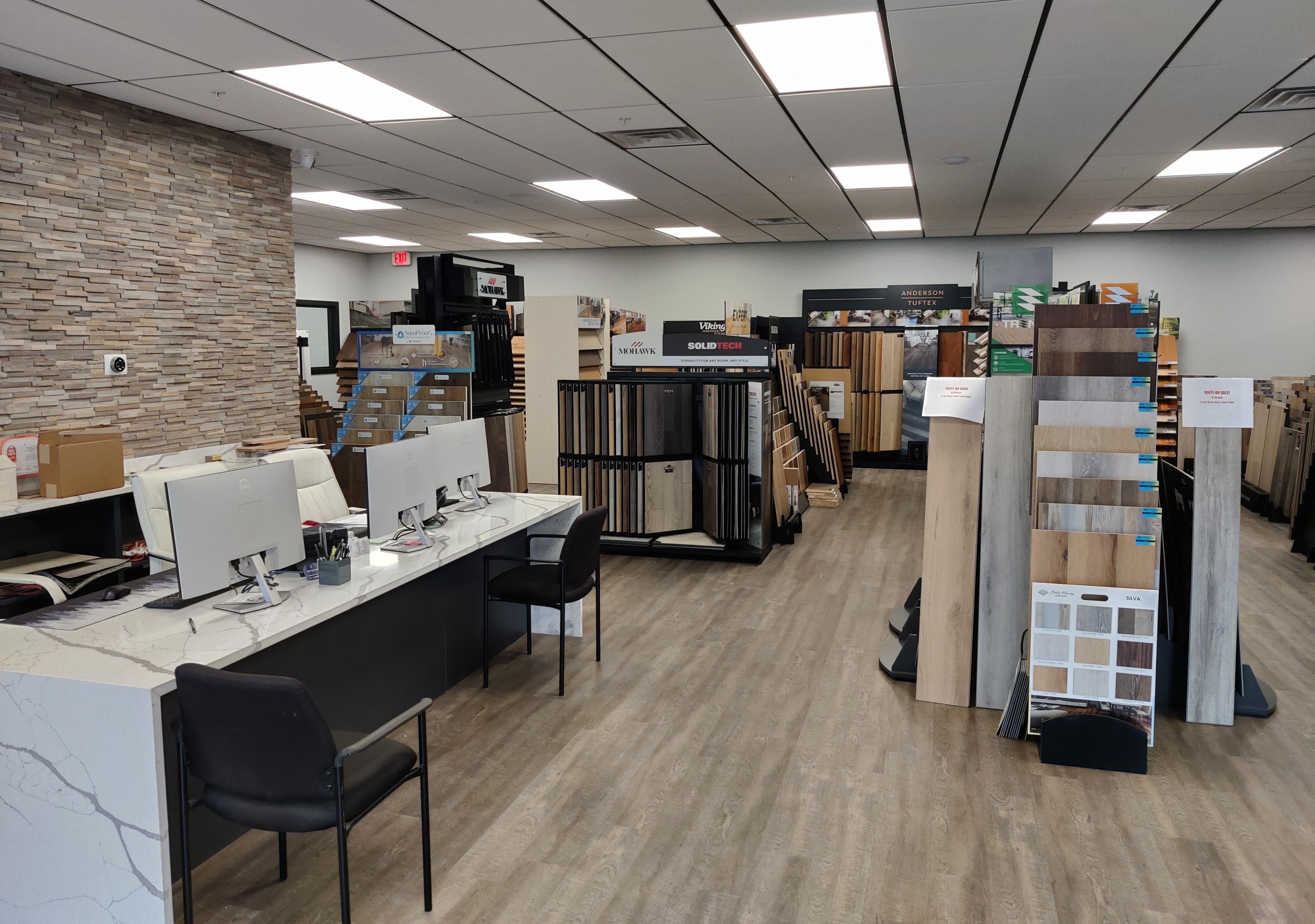 Creative Flooring Inc store with displays of various flooring samples and two computer stations. 